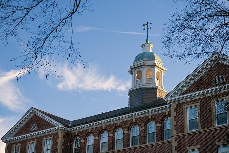 The roofline of Smith Hall set against a blue sky with wispy clouds