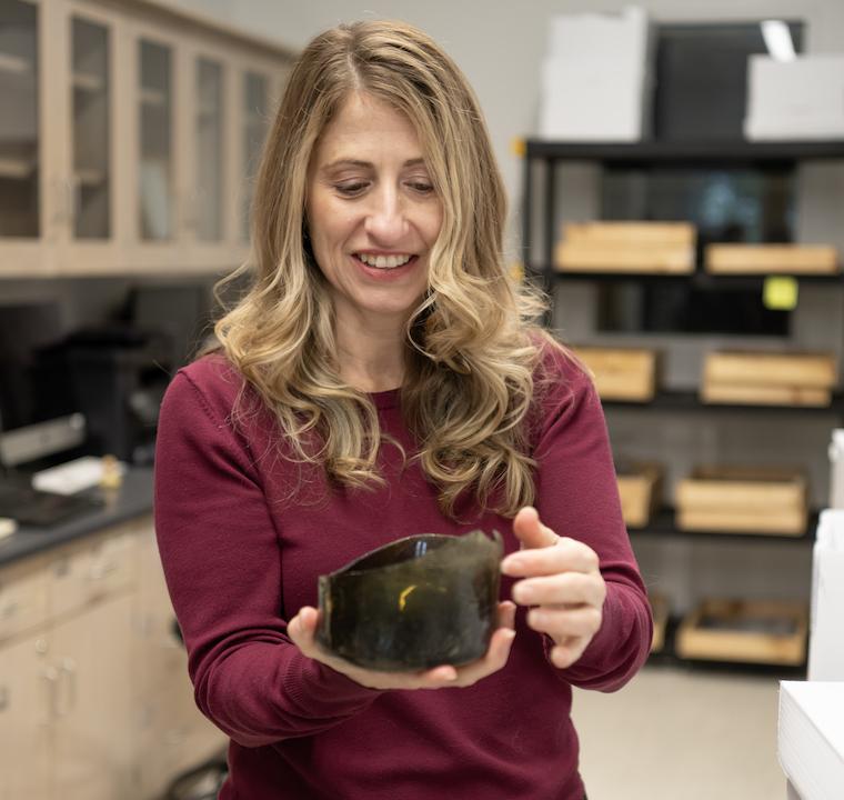 Julie Markin holds an artifact from a recent regional excavation